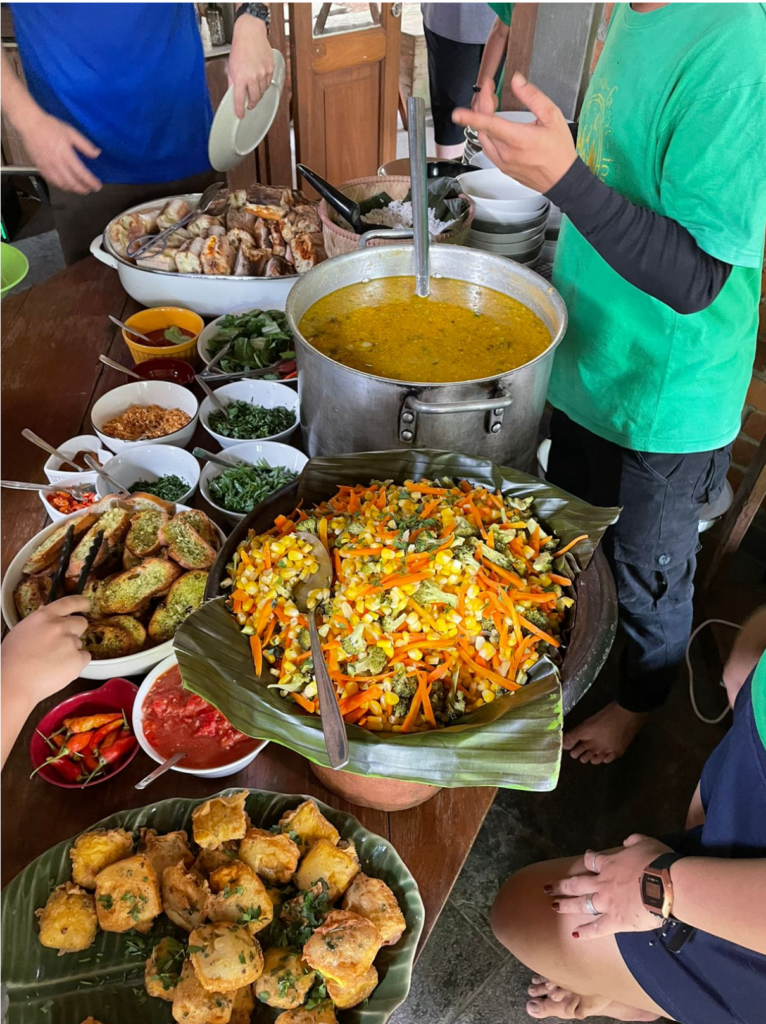 People serving themselves from a lunch buffet of sandwiches and soup.