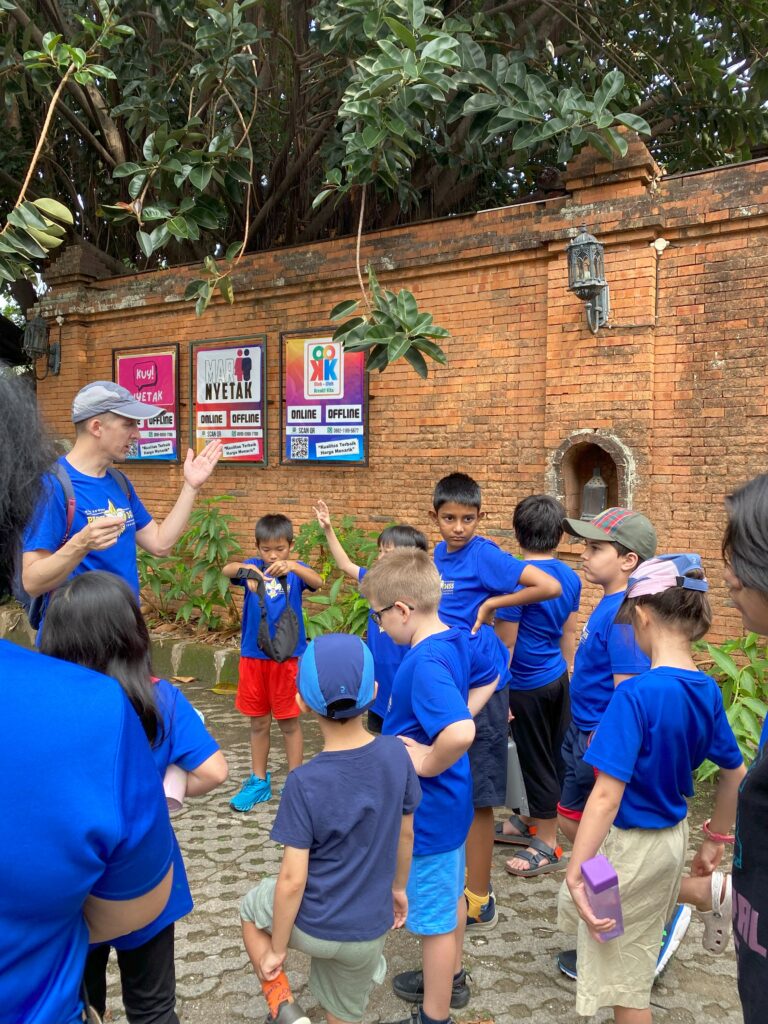 Group of kids in blue scout shirts in front of brick wall