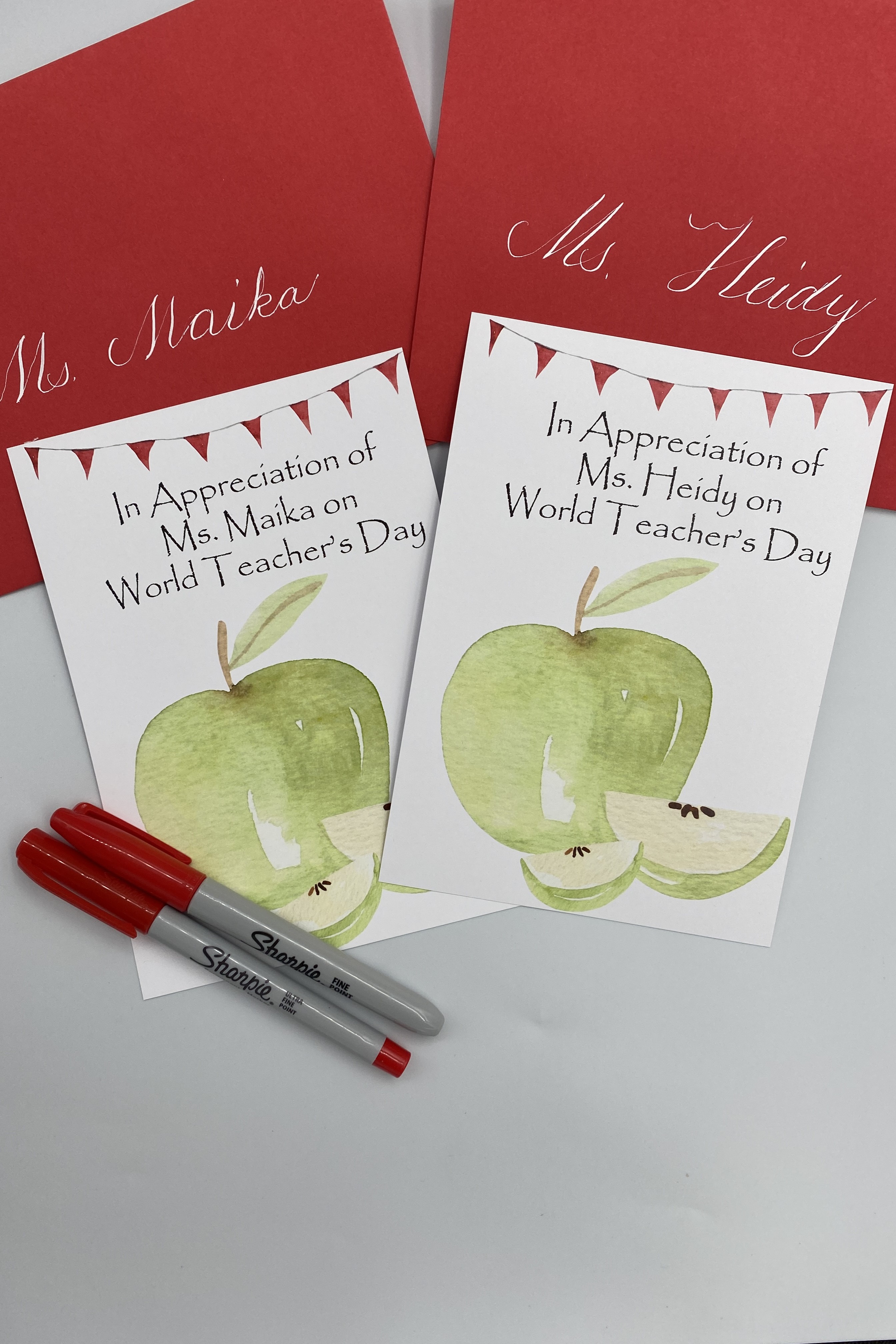 World Teacher's Day.  Green Apple, Red Envelope, White Calligraphy.